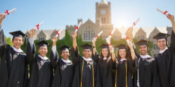 College graduates celebrating with diplomas on a university campus